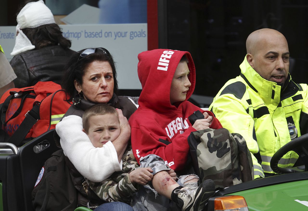 Women and children are escorted away from the scene.