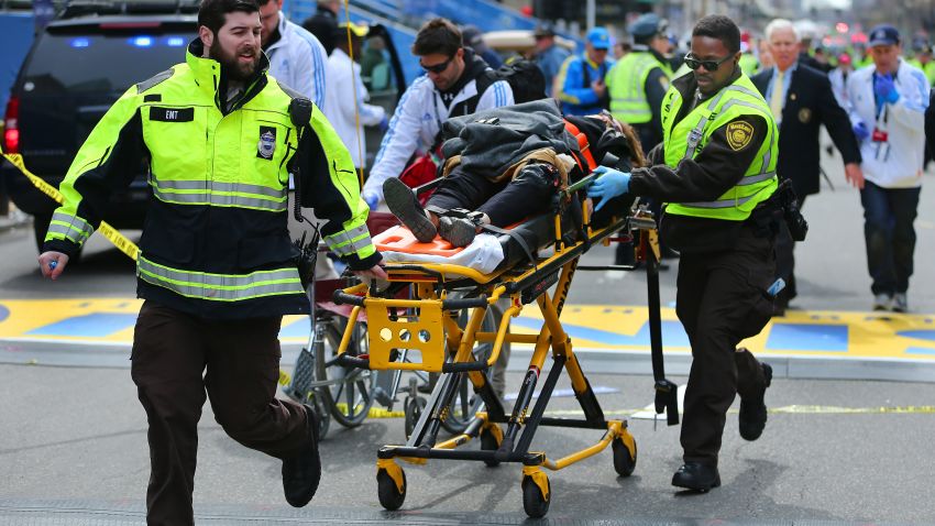 BOSTON - APRIL 15: A person who was injured in the first explosion is wheeled across the finish line of the Boston Marathon. (Photo by John Tlumacki/The Boston Globe via Getty Images)