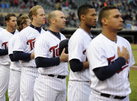 The Minnesota Twins stand during the national anthem before a baseball game in Minneapolis on April 15, 2013.