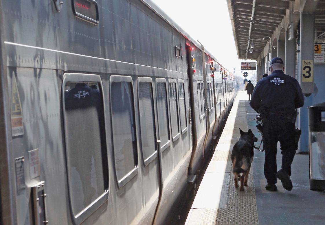 A police officer and his dog guard a Long Island Rail Road train at the station in Hicksville, New York, on Monday. <a href="http://www.cnn.com/SPECIALS/us/boston-bombings-galleries/index.html">See all photography related to the Boston bombings.</a>
