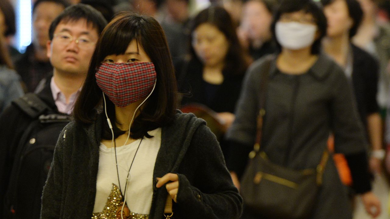 Women wear facemasks as the city's commuters protect themselves against the H7N9 bird flu virus in the downtown area of Shanghai in 2013.