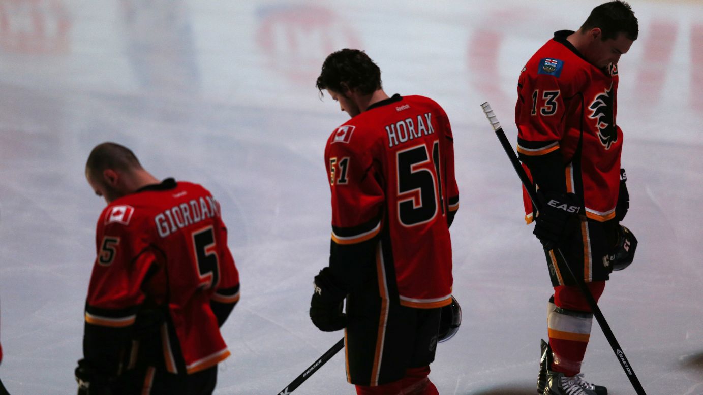 Members of the Calgary Flames observe a moment of silence before the start of their National Hockey League game against the Minnesota Wild in Calgary, Alberta, on Monday, April 15.