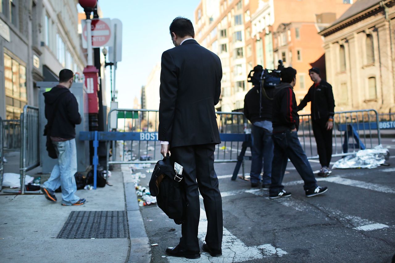 People congregate at a security gate near the blast scene on April 16.