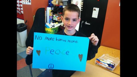 Martin Richard, the 8-year-old killed during the Boston Marathon bombings, holds a sign calling for peace. 