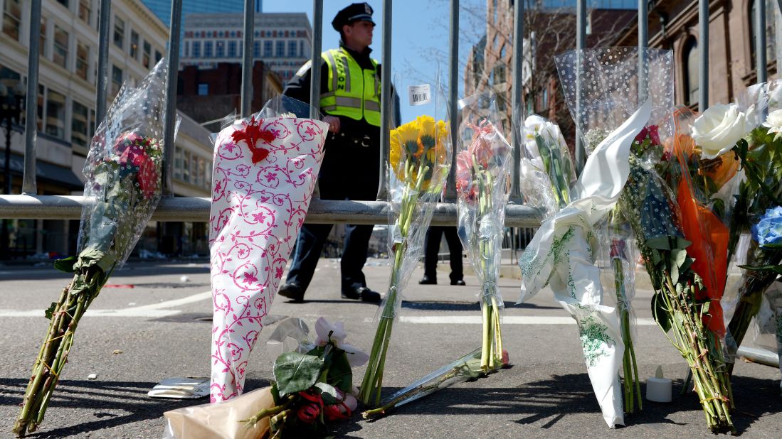 Flowers rest against a police barricade down the street from the Boston Marathon's finish line on April 16.