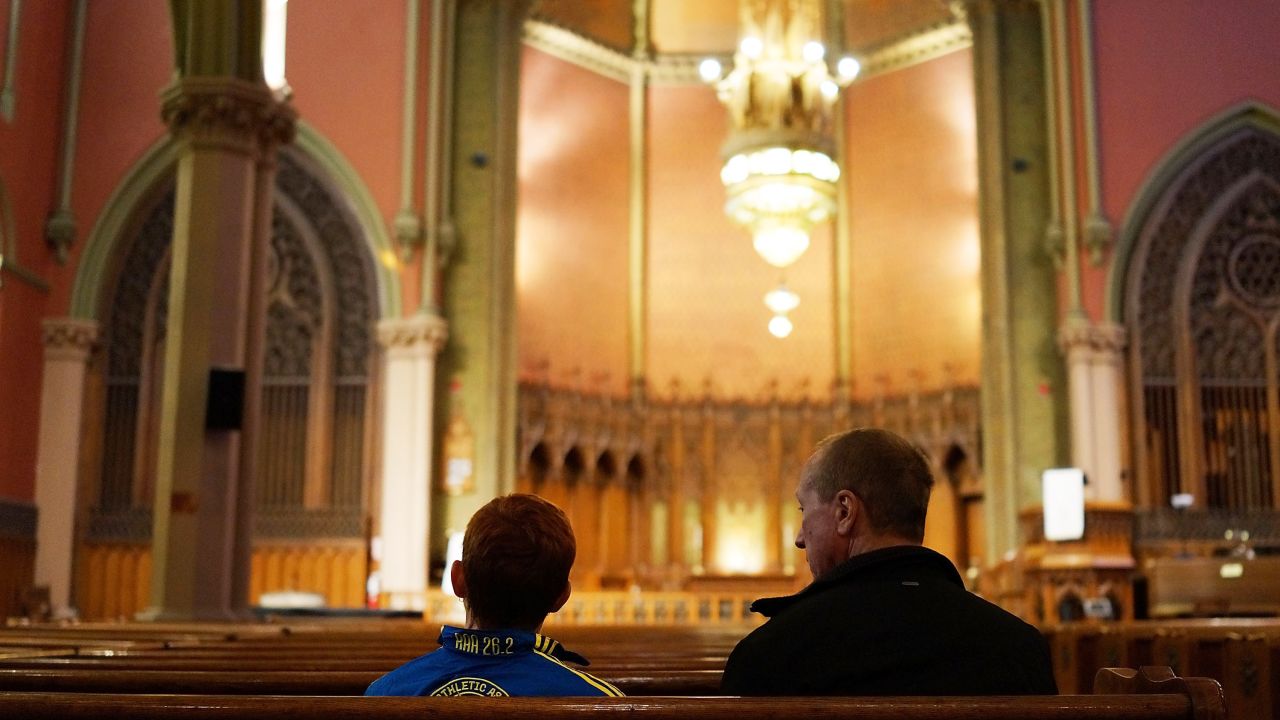 A young runner, left, stops by a Boston church blocks away from the scene of the bombings. The blasts exploded near the Boston Marathon's finish line on Monday, April 15, killing three people and injuring more than 170 others. <a href="http://www.cnn.com/SPECIALS/us/boston-bombings-galleries/index.html">See all photography related to the Boston bombings.</a>