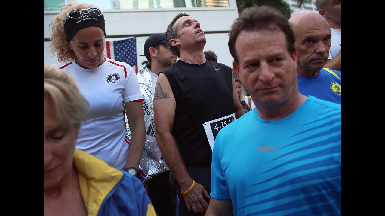 Five-time Boston Marathon runner Jose Sotolongo, center, reacts during a moment of silence in Miami on April 16, 2013.