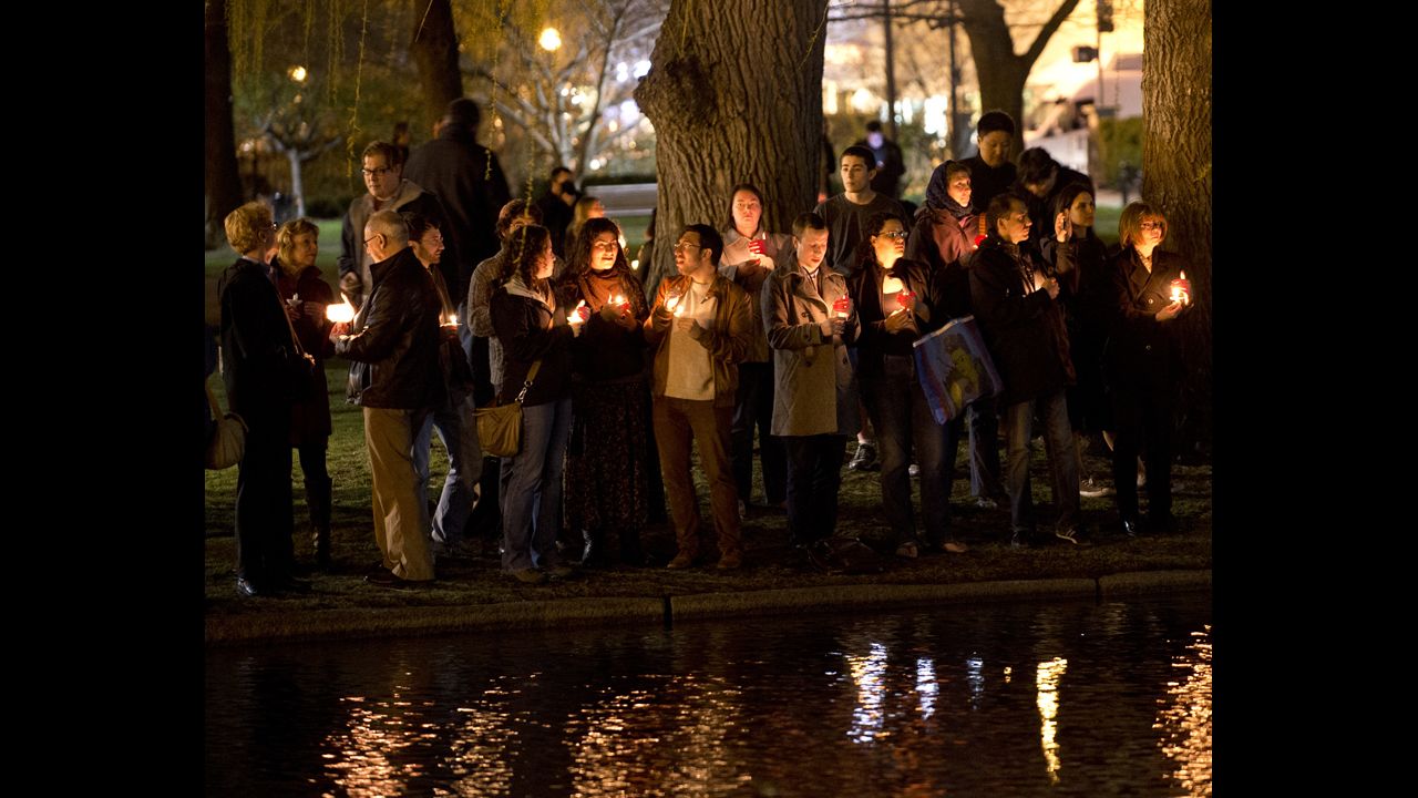 Mourners gather on the edge of the pond for a candlelight vigil in Boston on April 16, 2013.