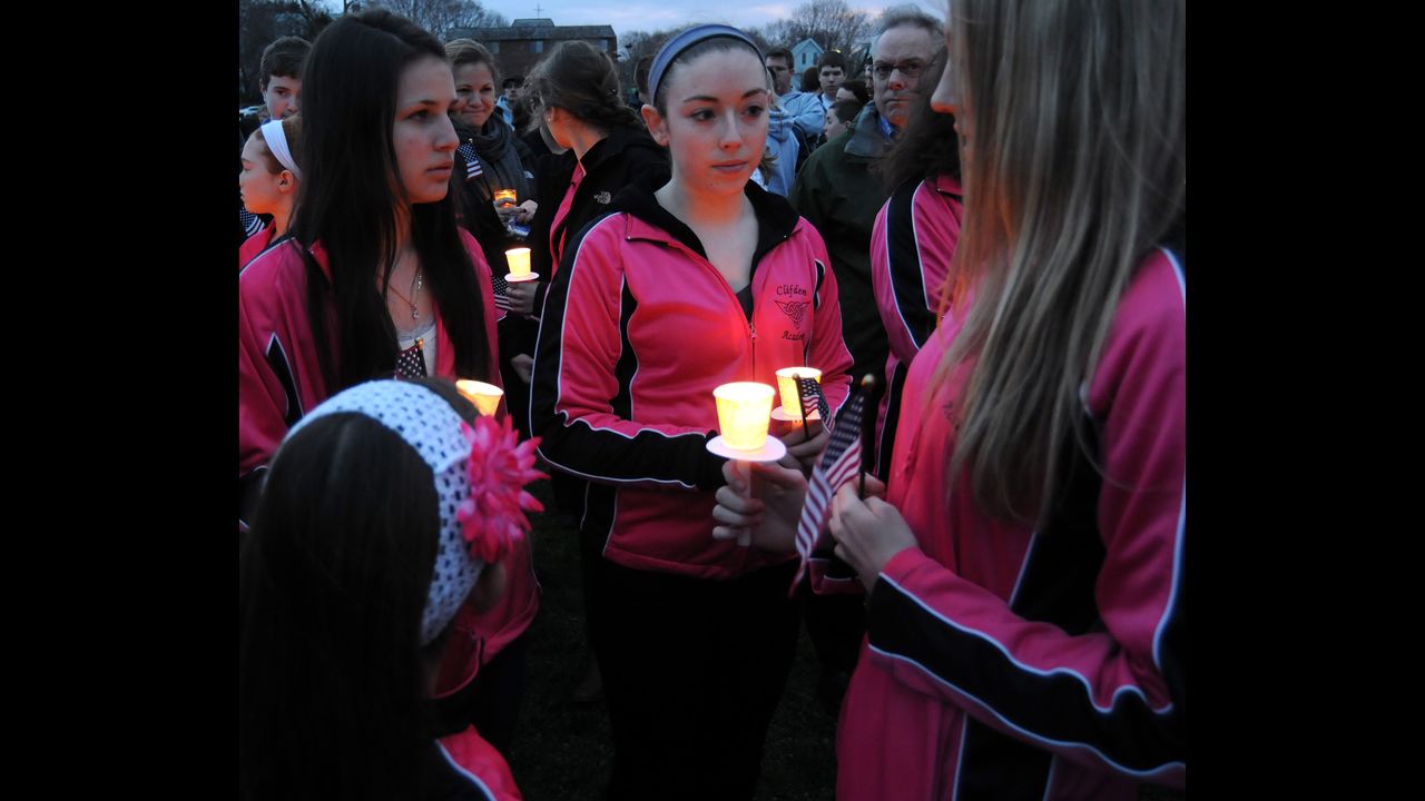 Students from the Clifden Academy hold an American flag and candles during a vigil in Dorcester, Massachusetts, on April 16, 2013.
