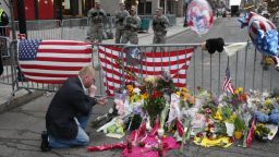 BOSTON, MA - APRIL 16: Mike Vitale, who lives in the Boston area, prays beside flowers and remembrances for victims of the bombing of the Boston Marathon at a roadblock at the end of Boylston Street, on April 16, 2013 in Boston, Massachusetts. Two bombs exploded near the finish line of the marathon the day before, killing some and injuring more than 100 people.(Photo by Melanie Stetson Freeman/The Christian Science Monitor via Getty Images)