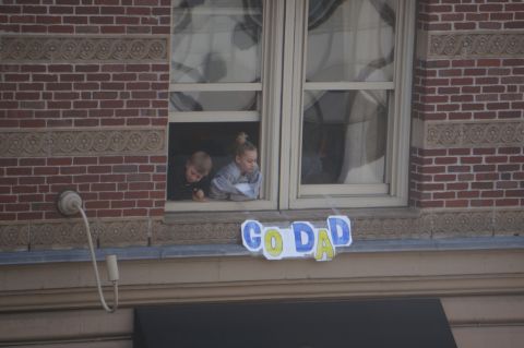Children watch the race from a window.