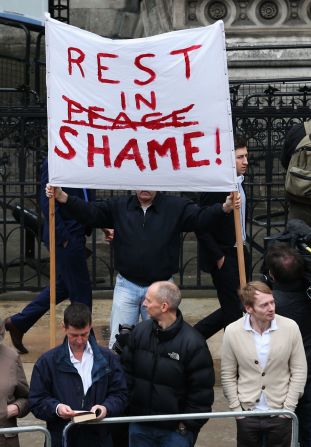 A protester holds a banner at the Church of St. Clement Danes in London.