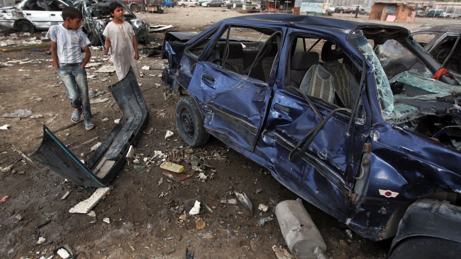 Iraqi boys inspect the site of a car bomb attack in Baghdad's district of Sadr City on April 16, 2013.