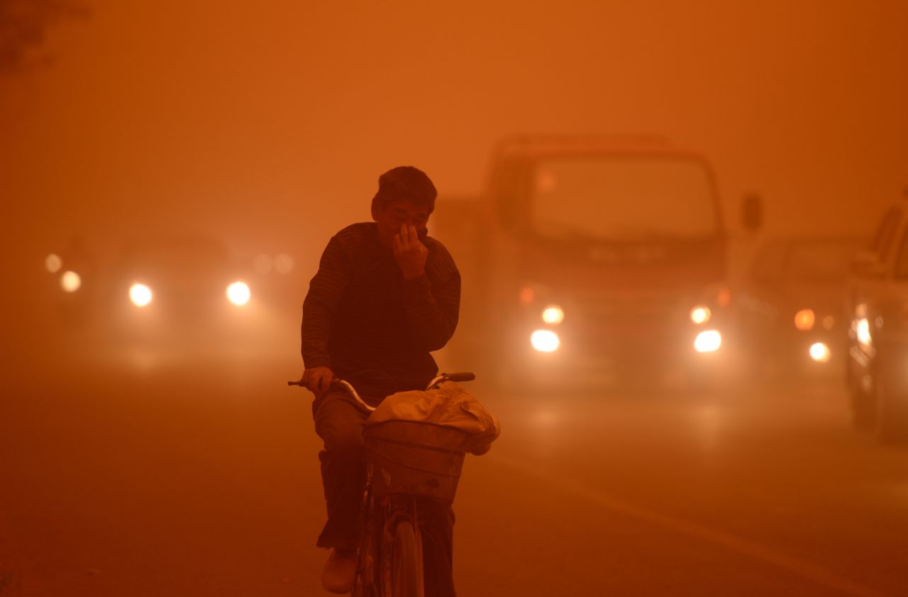 A man rides a bike during a heavy sandstorm in Yecheng county, northwest China's Xinjiang Uygur Autonomous Region, on Tuesday, April 16.