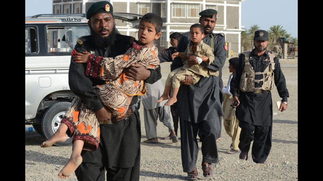 Pakistani Frontier Constables carry survivors toward an army helicopter in Mashkell on Thursday.