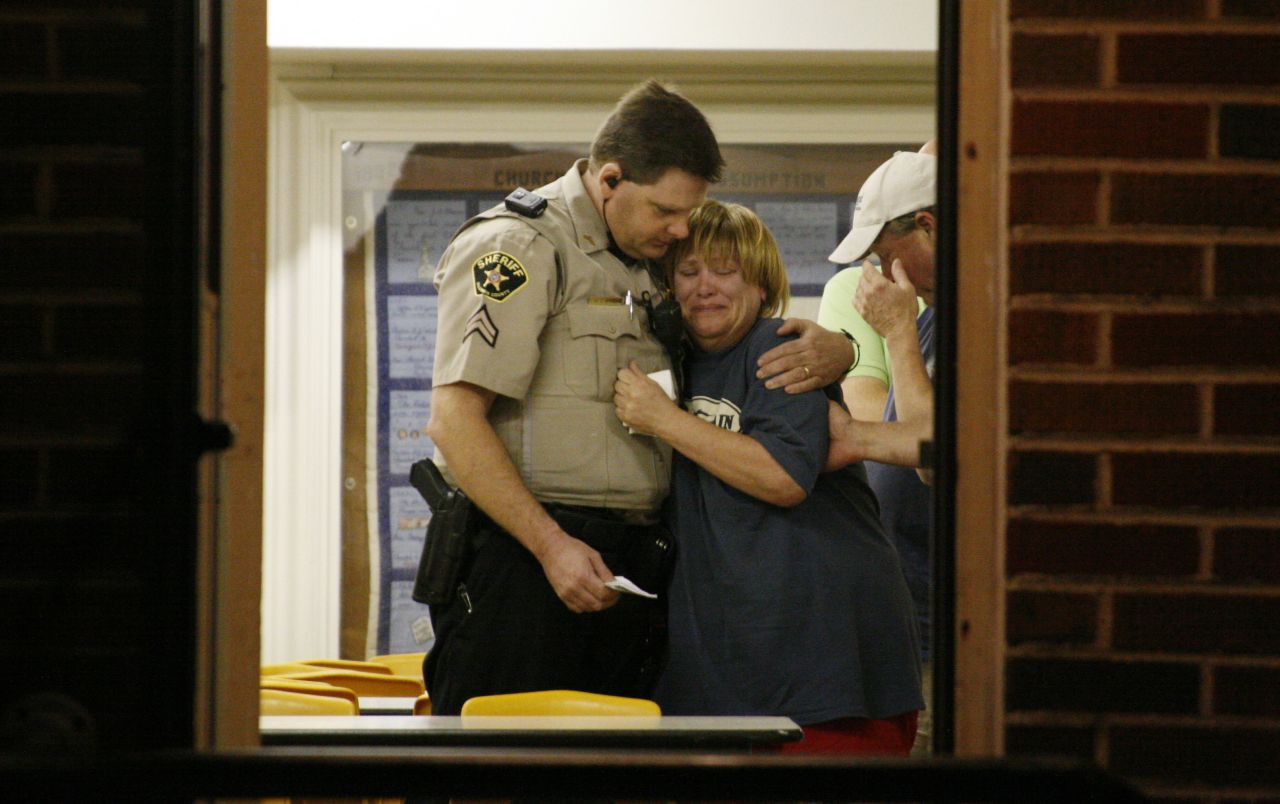 A sheriff's deputy comforts a woman at a command post.