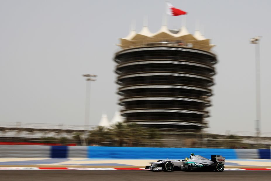 The imposing Sakhir Tower looms over the cars as they race on the Bahrain International Circuit.