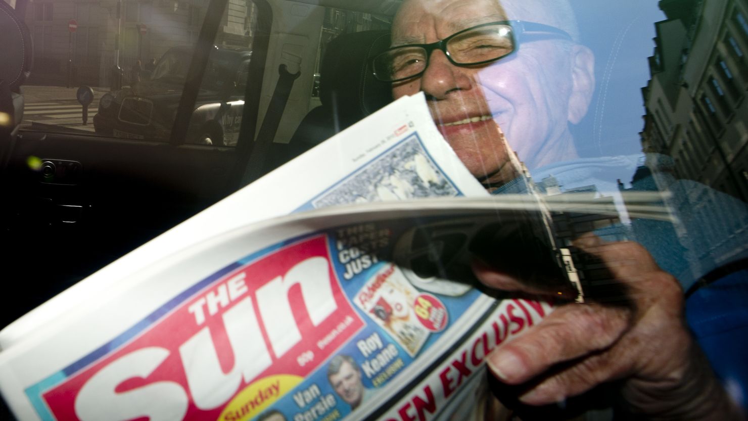 (FILE) Rupert Murdoch holds a copy of 'The Sun on Sunday' newspaper on February 26, 2012.