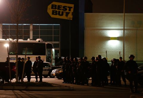 Boston Police gather in the parking lot in front of a Best Buy store near the Watertown Mall on Friday.