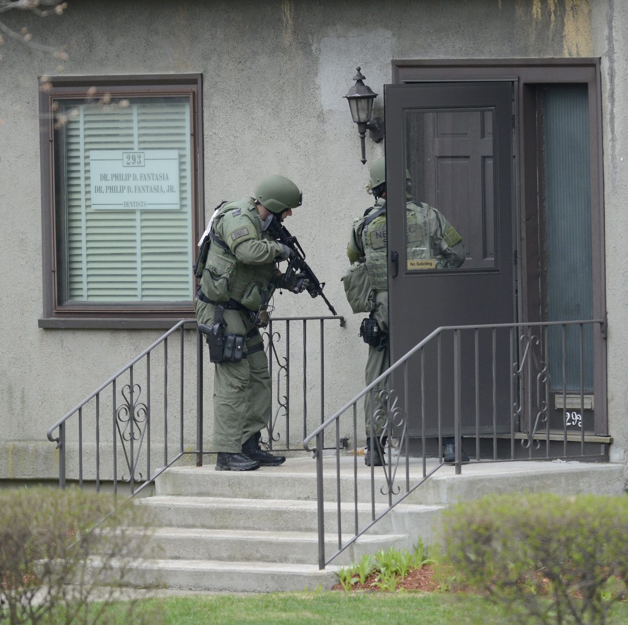 SWAT officers check a door with guns ready on Friday.