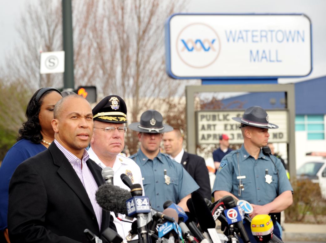 Massachusetts Gov. Deval Patrick, left,  speaks to the media at a shopping mall on the perimeter of a locked-down area during the search on Friday.