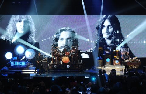 Alex Lifeson, Neil Peart, and Geddy Lee of Rush perform onstage.
