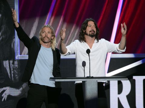 Taylor Hawkins, left, and Dave Grohl  of the Foo Fighters help induct Rush into the Rock and Roll Hall of Fame.