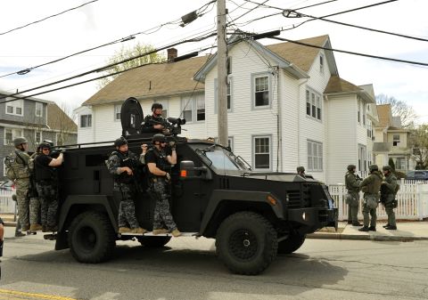 A police SWAT team searches houses on April 19 for the second suspect.