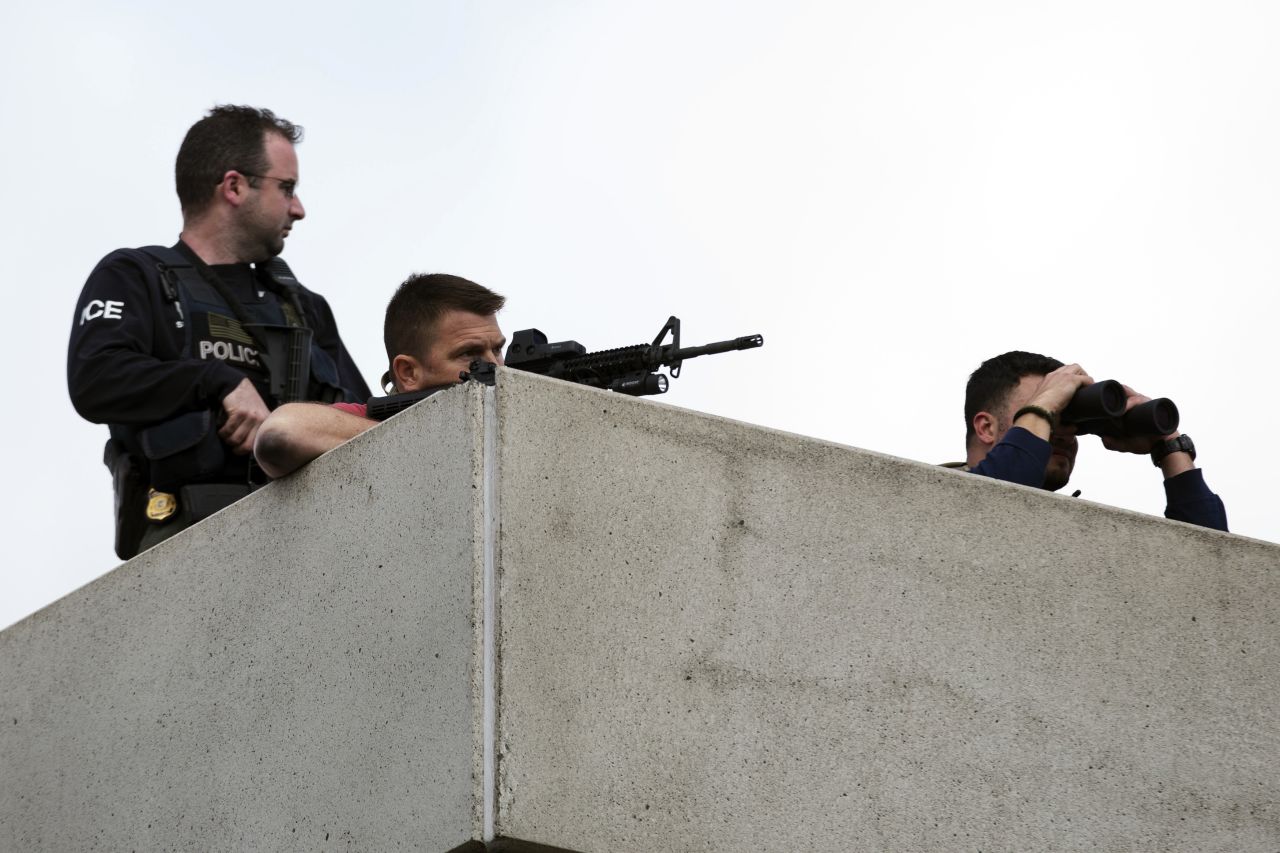 Law enforcement officers place themselves in an overhead position on Arsenal Street as the search continues on April 19.