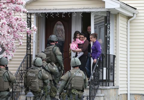 SWAT teams prepare to enter a home as they continue the door-to-door search.