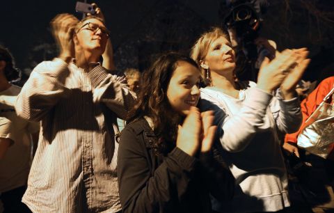 Onlookers applaud first responders departing the scene at the end of the manhunt on April 19.