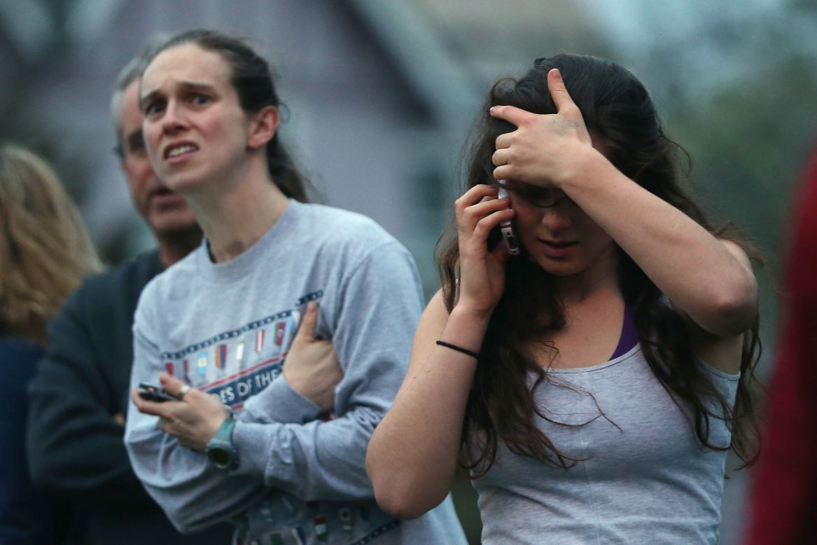 People react while watching police respond to reported gunfire on April 19.