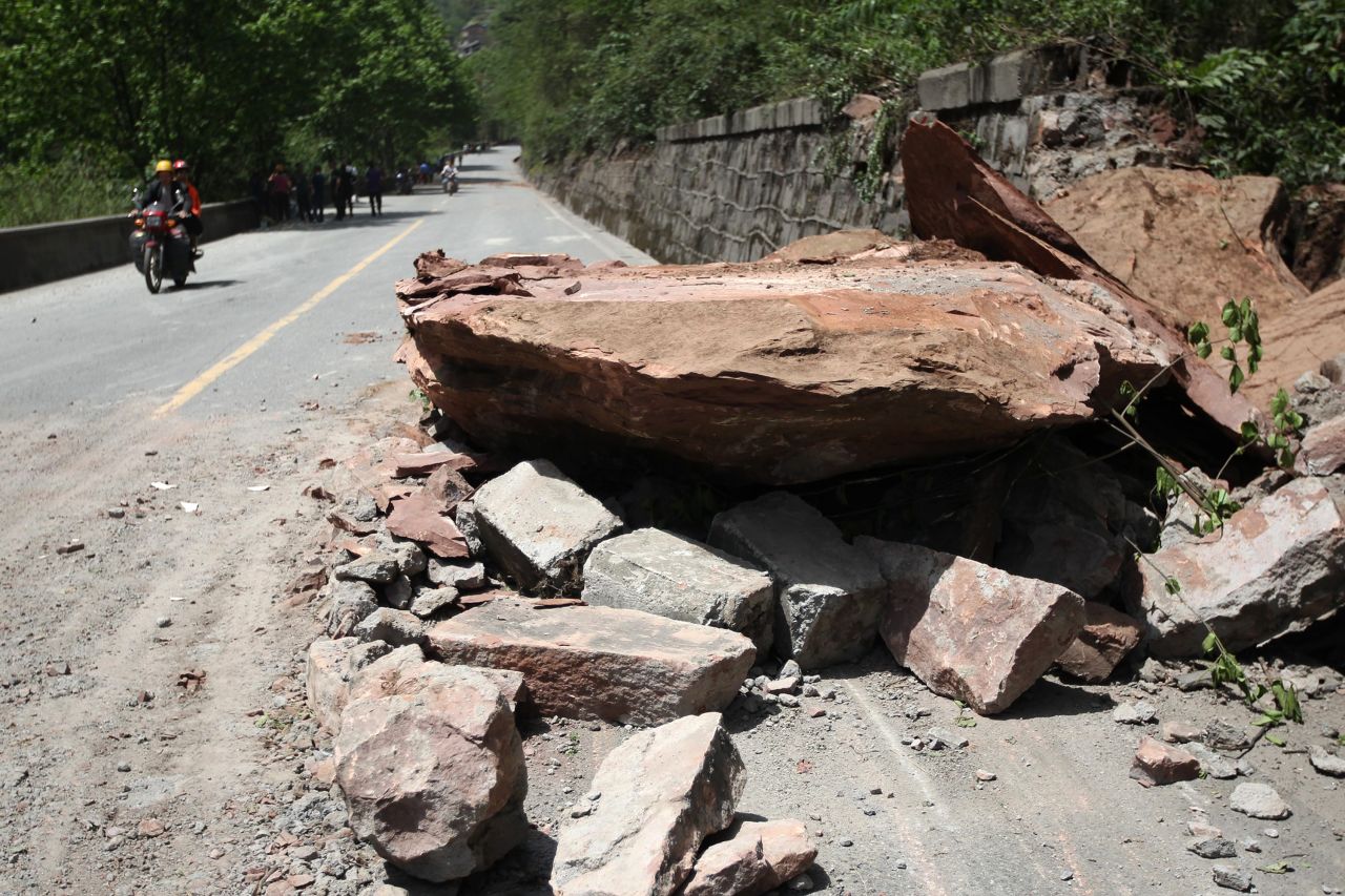 Huge rocks lie on a road in Longmen on Saturday.