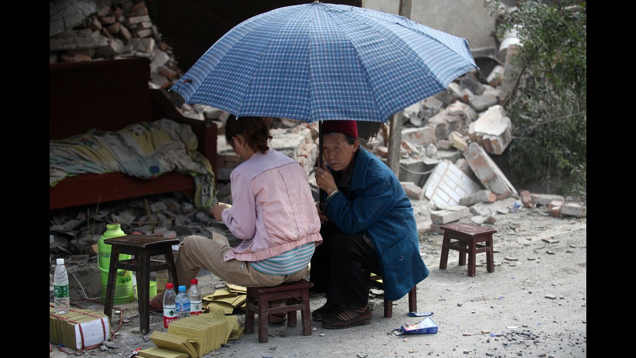 A girl gives offerings to the dead by the side of ruins in Longmen on Saturday.