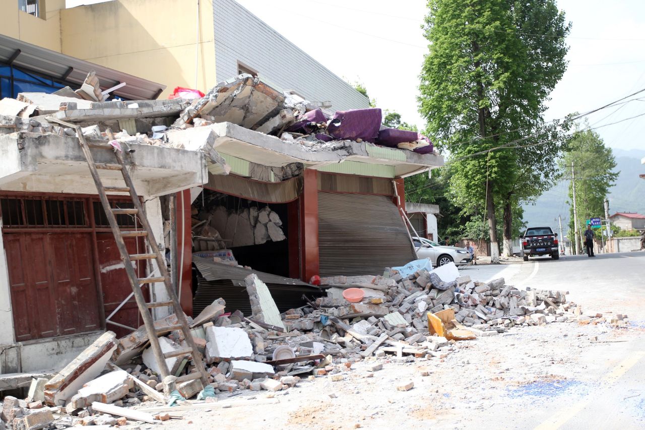 Rubble covers roadside houses in Longmen on Saturday.