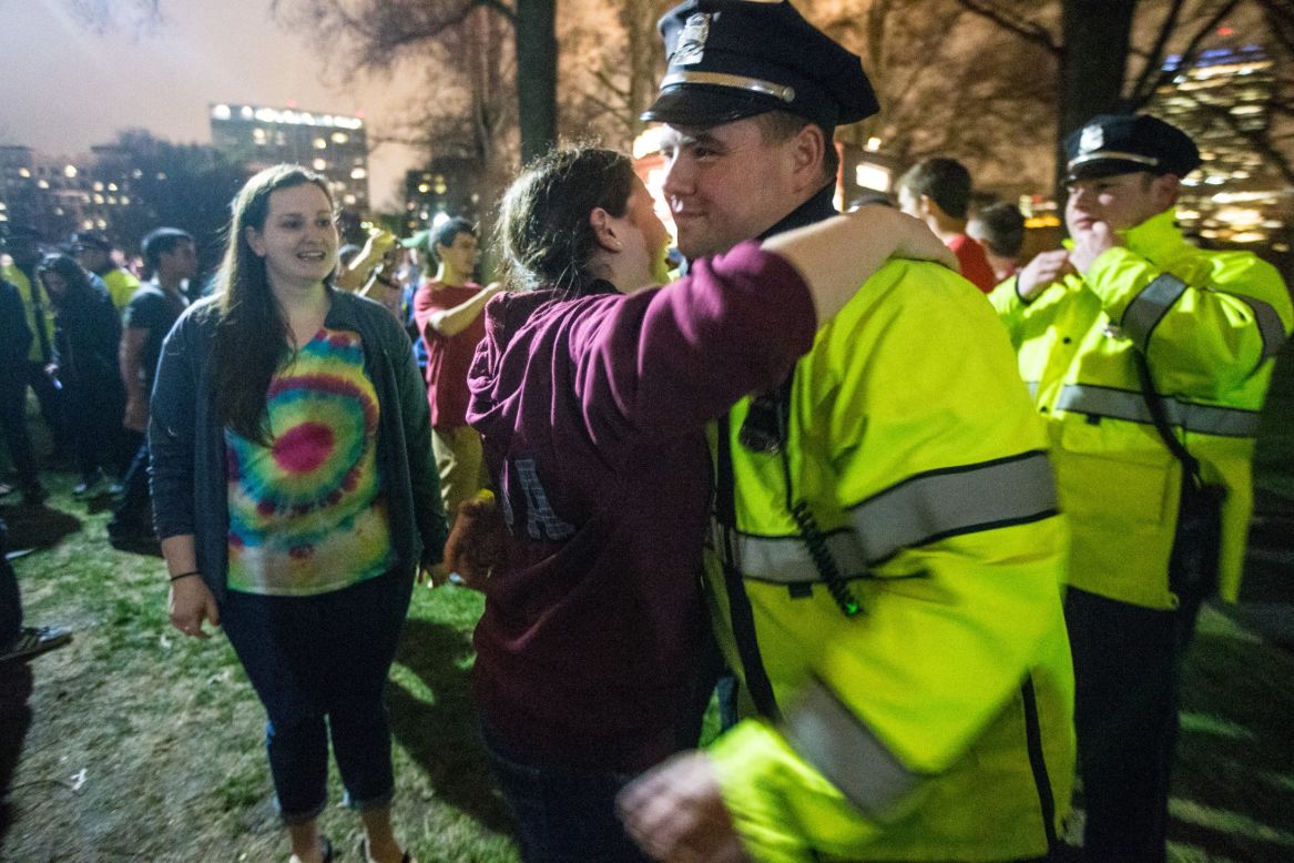 A woman gives a Boston police officer a hug and other officers are thanked during a celebration in the Boston Common on April 19.