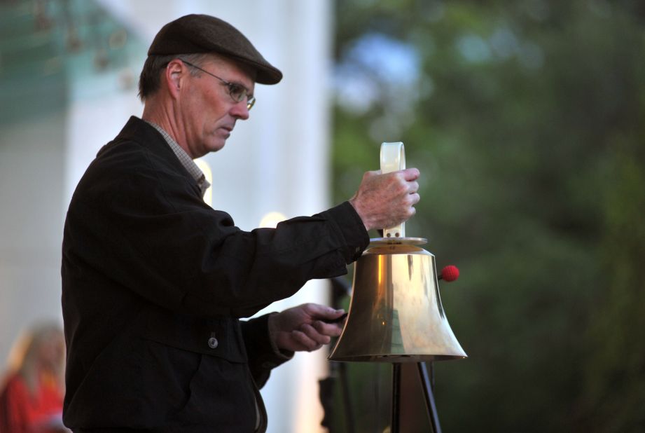 A man rings a bell at the vigil in Huntsville.