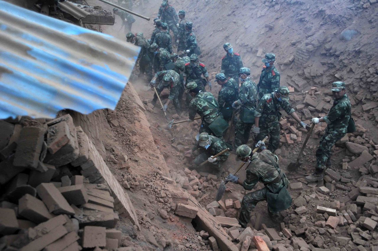 Rescuers dig through rubble in quake-hit Qingren township in southwest China's Sichuan Province on Saturday, April 20.