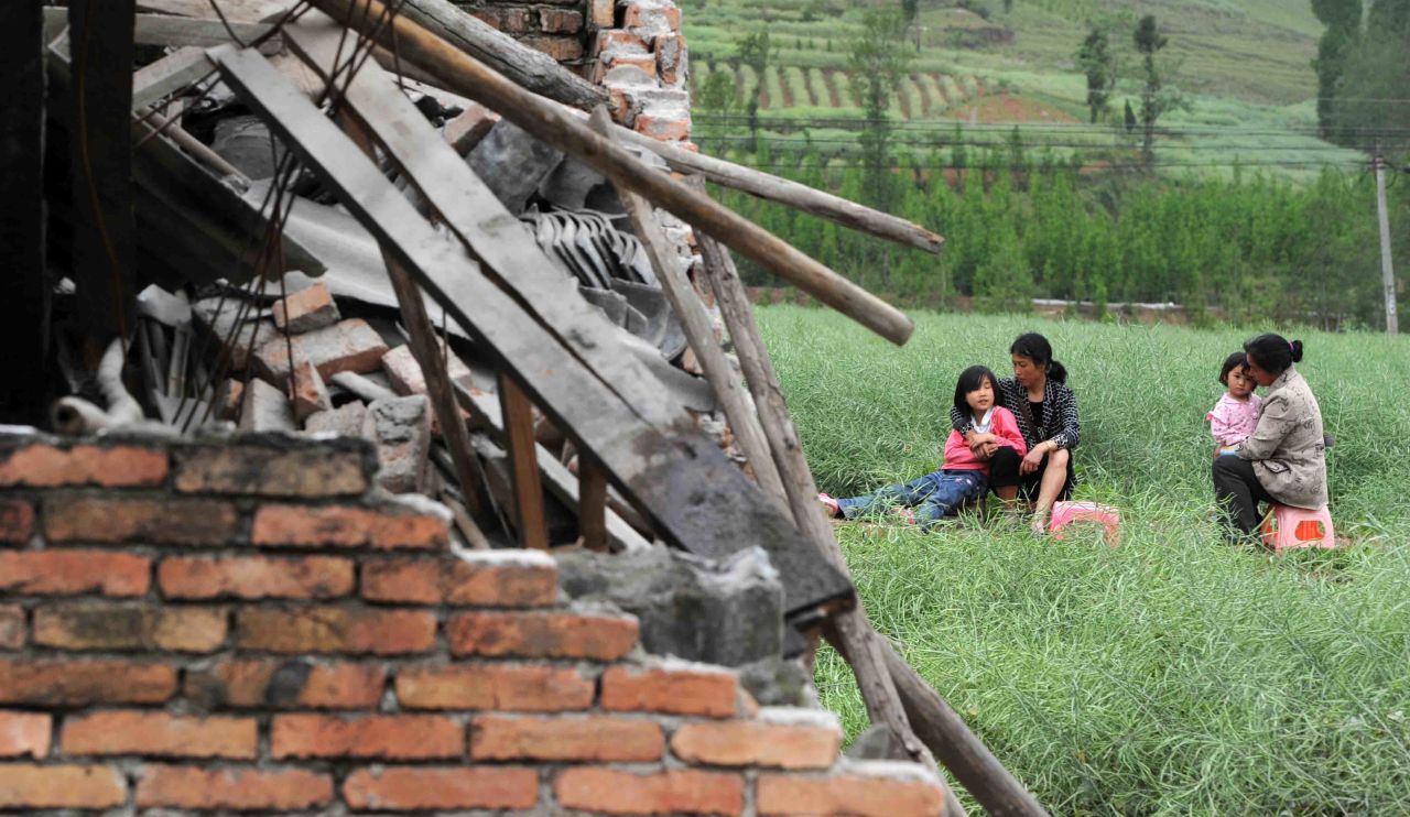 Residents rest near destroyed houses in Sichuan Province on Saturday.