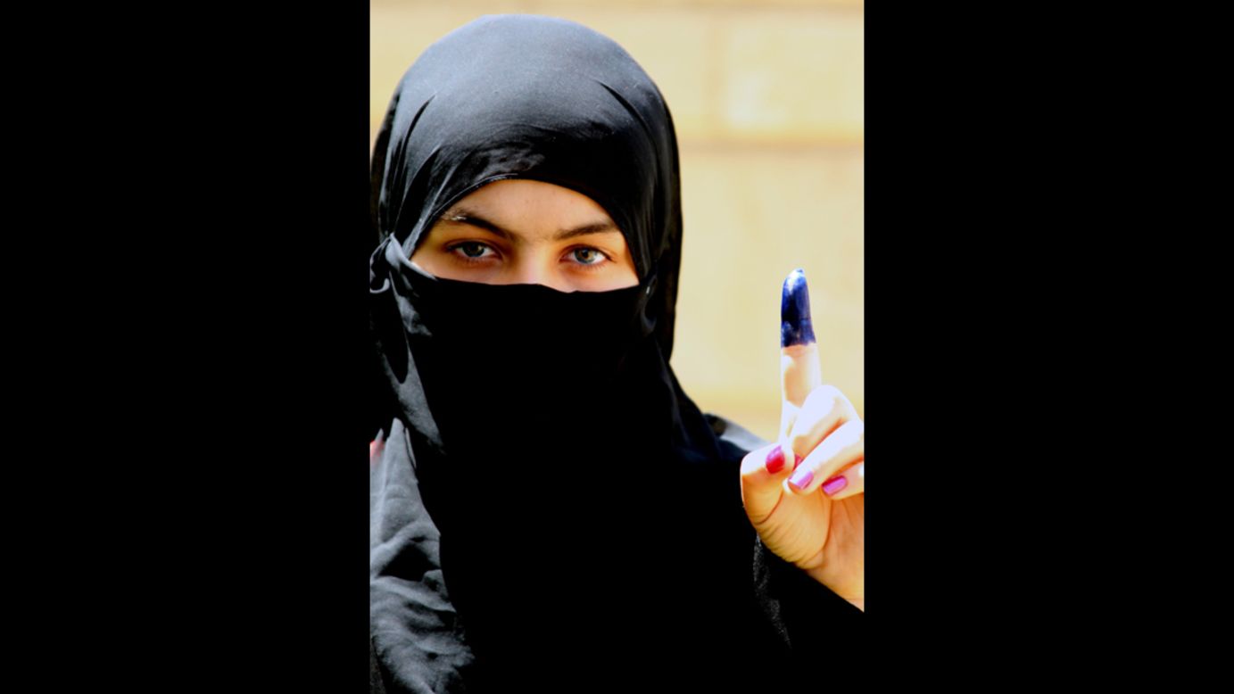 An Iraqi woman shows her ink-stained finger, indicating she cast a ballot at a polling station on Saturday.