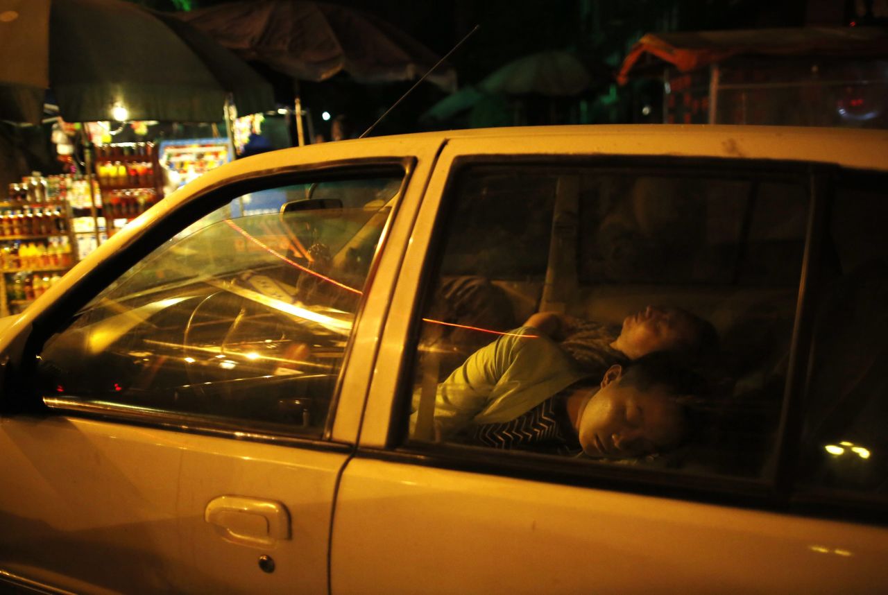 Chinese residents sleep in a car on Sunday to avoid danger from aftershocks.