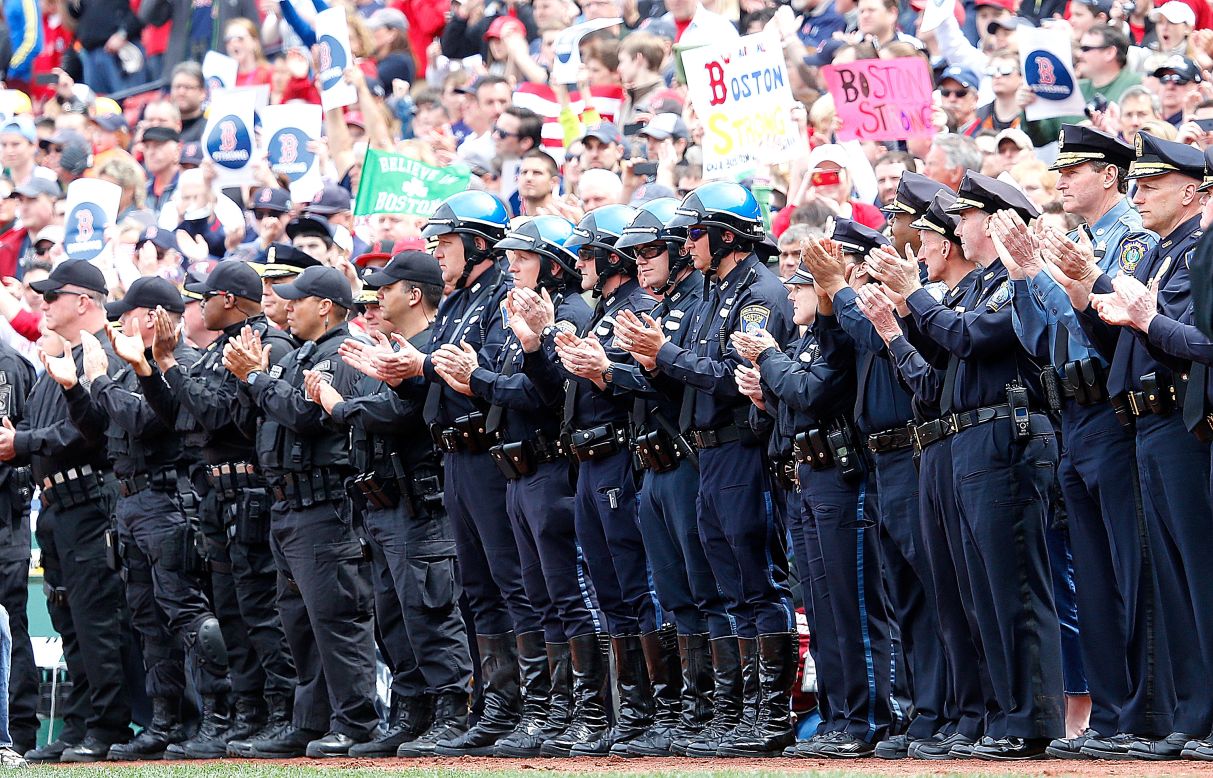 Members of law enforcement react during ceremonies in honor of the Marathon bombing victims before Saturday's game.