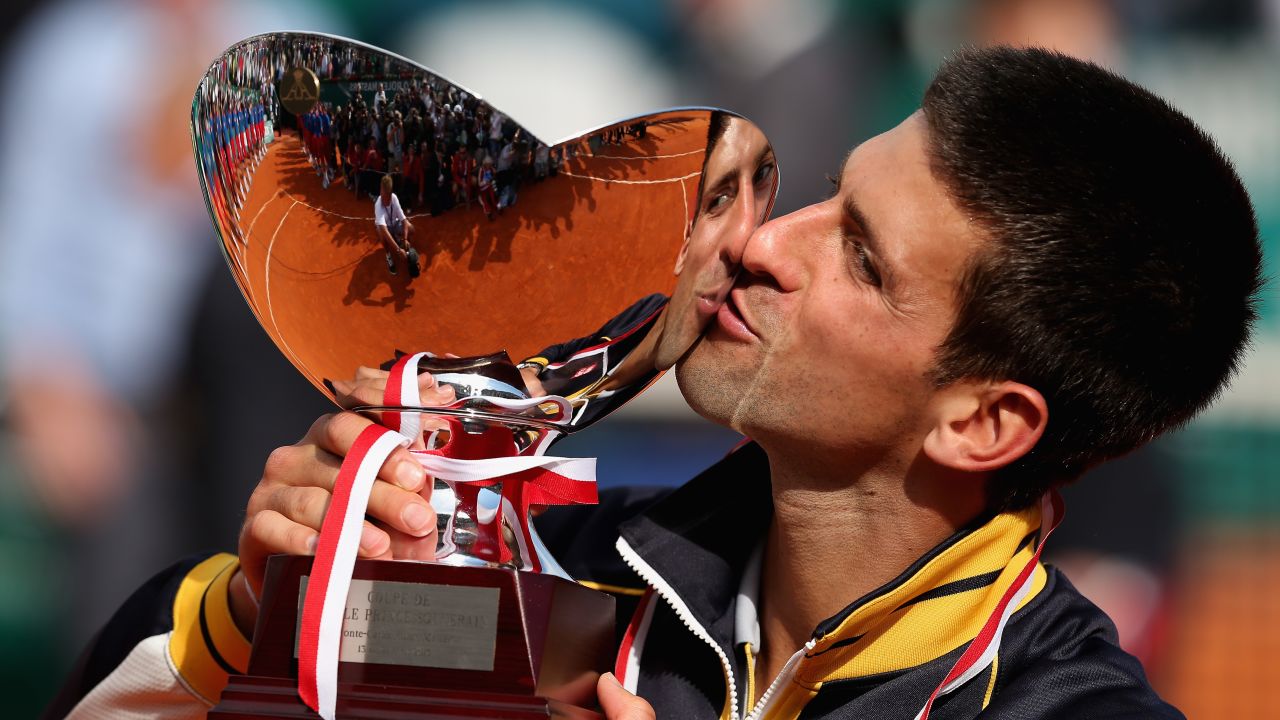 Serbian tennis star Novak Djokovic kisses the trophy after his straight-sets victory against defending champion Rafael Nadal.