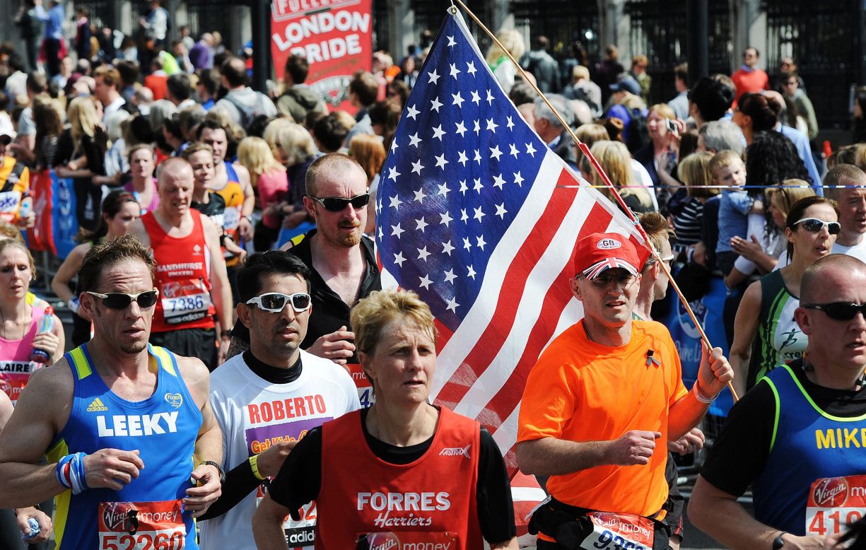 A man carries a U.S. flag as he runs with other marathoners during the London Marathon on April 21.