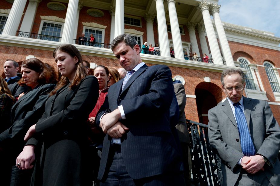 State employees pause for a moment of silence on the steps of the Massachusetts State House.