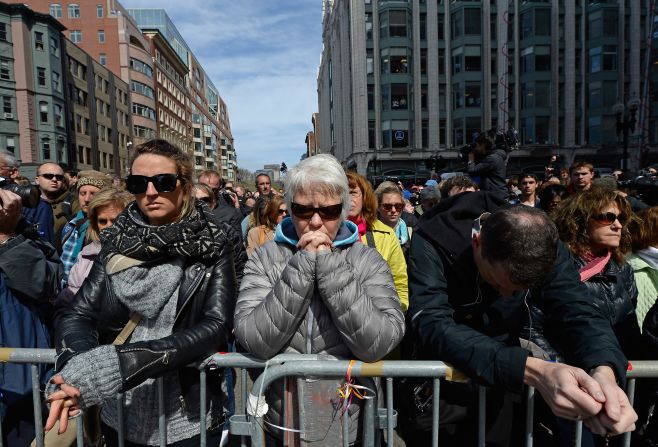 People take part in the moment of silence near the marathon finish line.