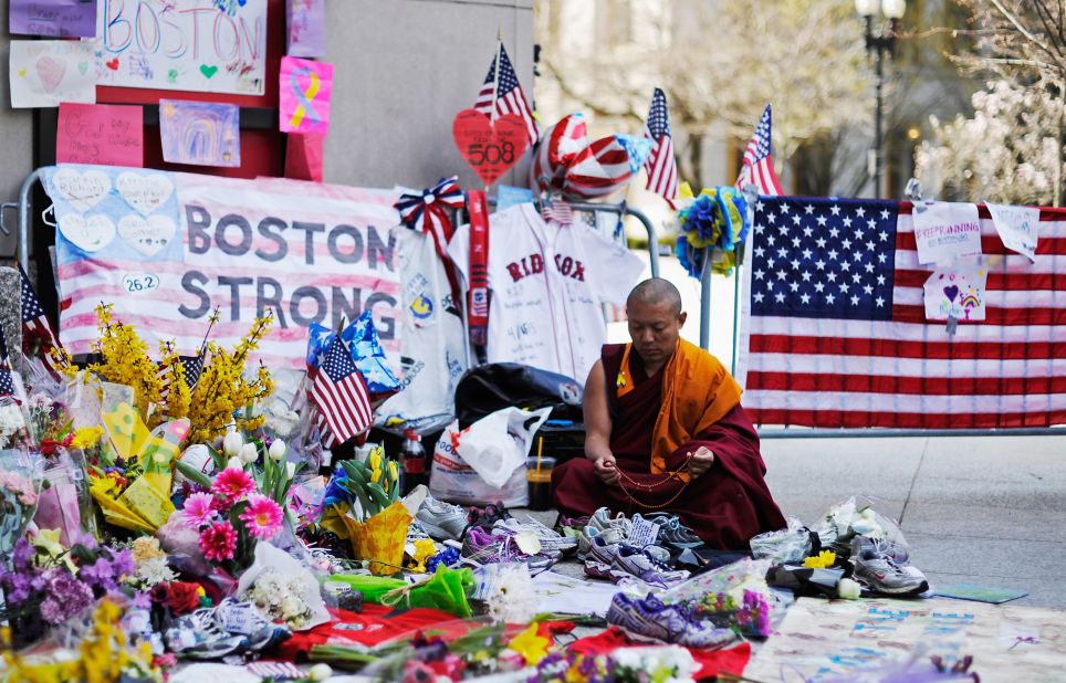 A Buddhist sits at a memorial near the marathon finish line during a moment of silence on April 22, 2013.