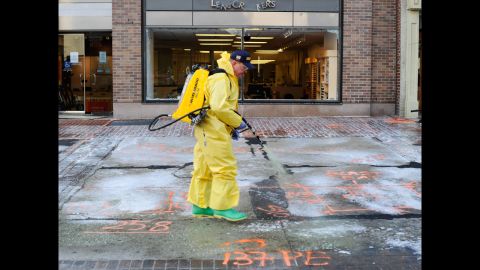 A member of the Boston Fire Department Hazardous Materials team cleans the first blast site with a pressure washer on April 22.