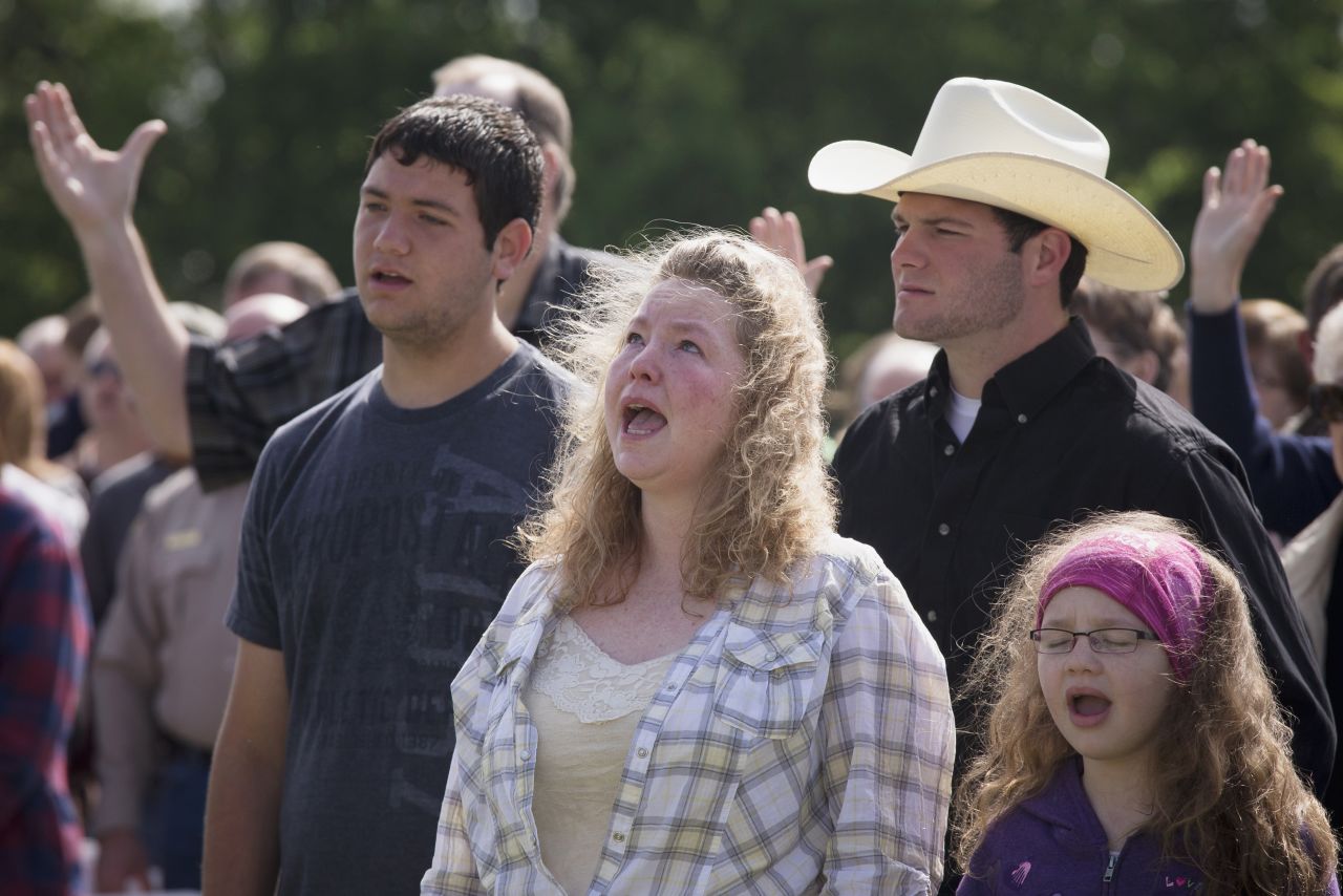 Vanna Wainwright and her daughter Breanna take part in an open air Sunday service on April 21. Members of the First Baptist Church held their service in an open air field after their church was damaged from the explosion. 