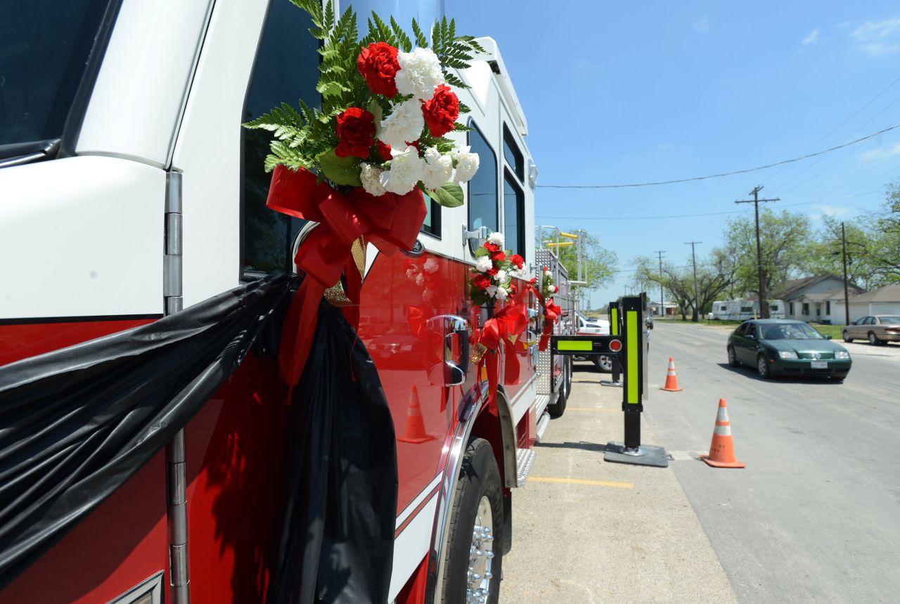 Flowers are tied on a firetruck on April 22 as a memorial for the firemen who died while responding to the explosion.